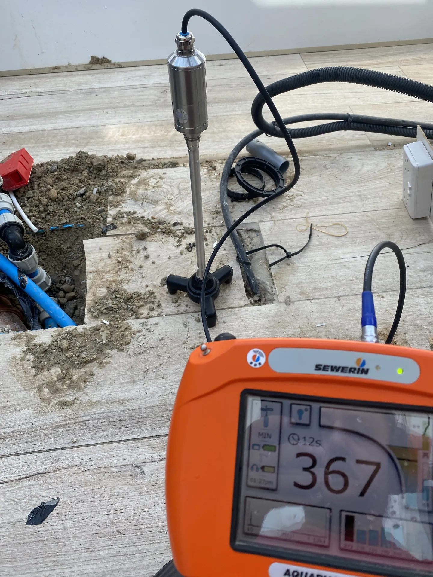 Acoustic leak detection kit with the floor microphone set up over a suspected leak