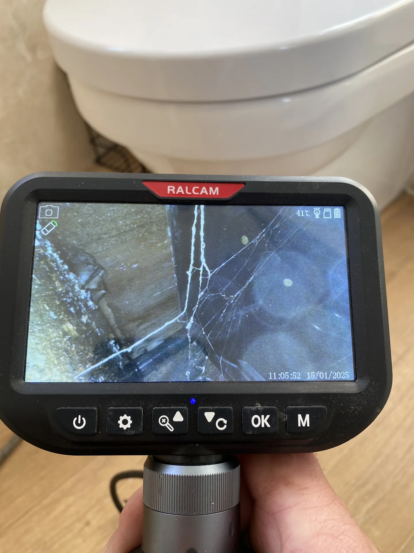 Borescope camera screen showing pipework under a bathroom floor